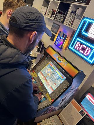 Besucher spielt an einem Arcade-Automaten