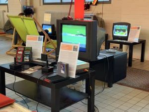 Retro-Gaming-Ausstellung mit Nintendo NES, Atari 2600 und Röhrenfernsehern mit laufenden Videospielen.